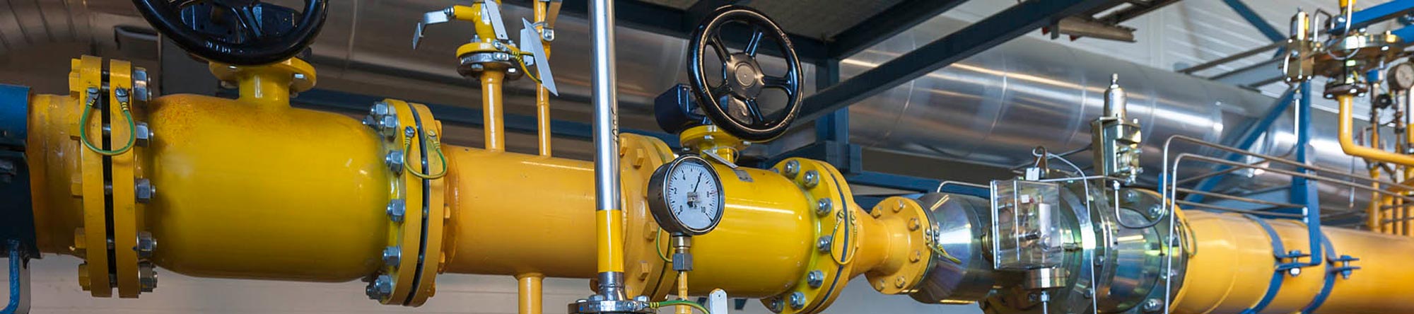 industrial setup with yellow pipes, valves, and a central pressure gauge